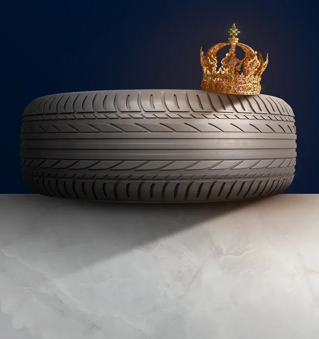 Pneu posé sur du marbre avec une couronne posé sur le dessus du pneu