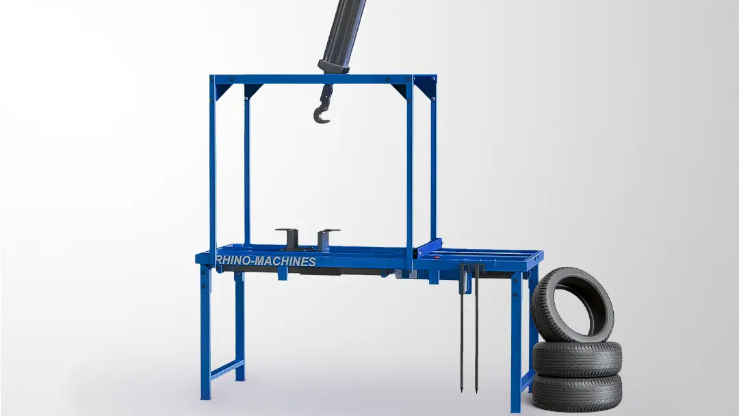 Machine à détripler les pneus pour déballer les pneus avec un lot de pneus posé à côté