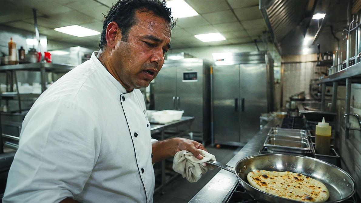 Chef cuisinier qui cuit un naan dépassé par les événements