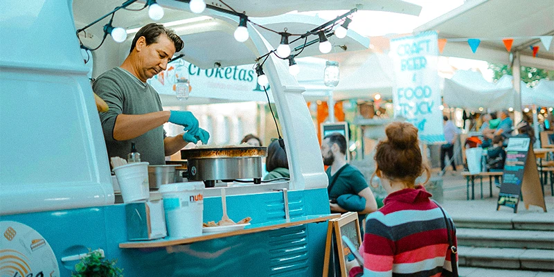 Homme dans un food truck servant une femme